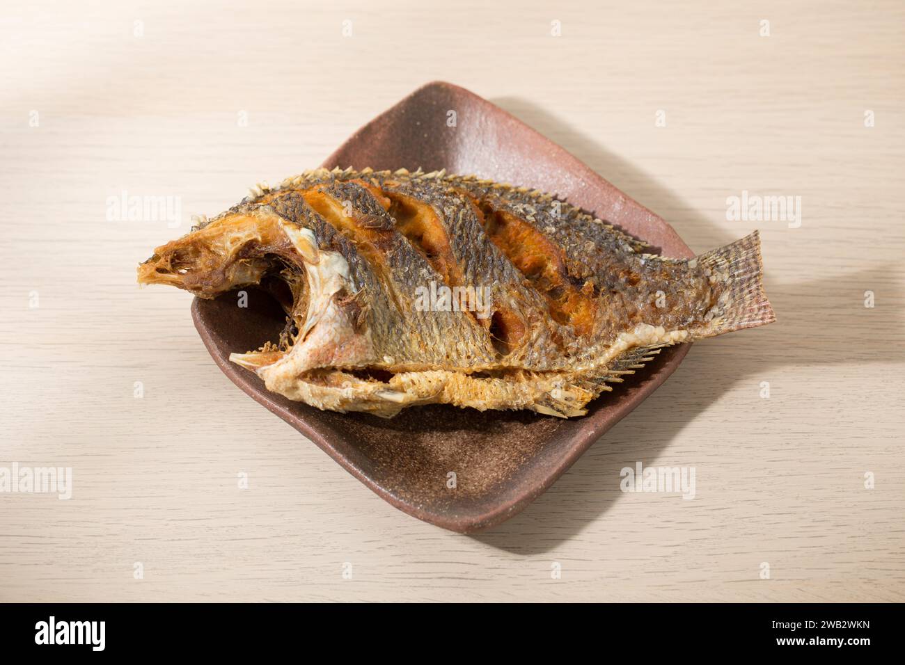 Fried tilapia with Thaistyle rice on a japanese style ceramic plate