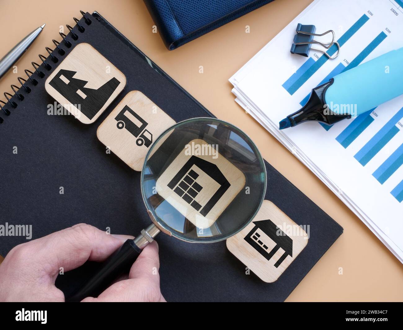 Product supply chain and warehouse. Hand holds a magnifying glass. Stock Photo