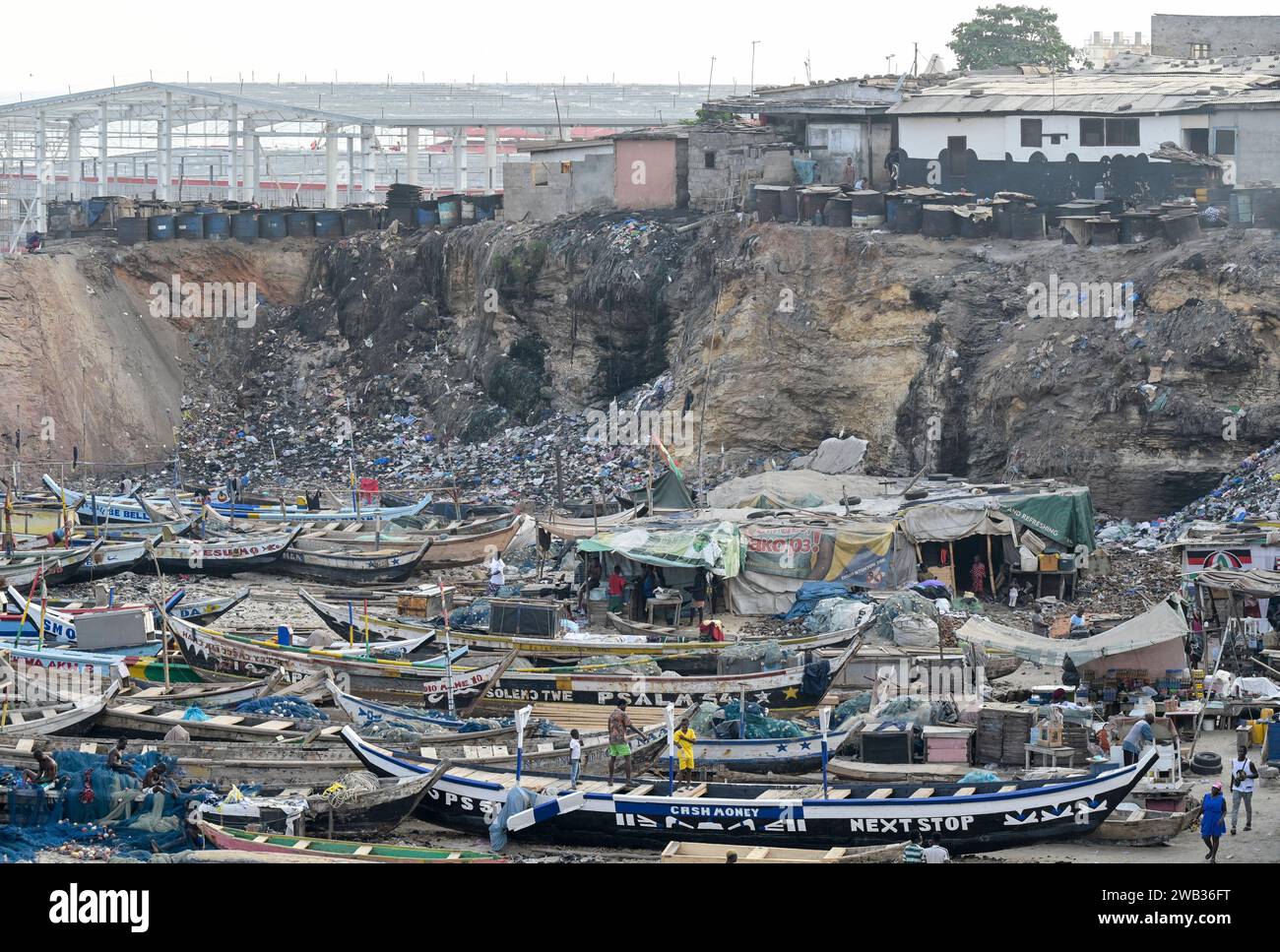 GHANA, Accra, Jamestown, old fishing port and behind construction site of new fishing harbour by chinese company CRCC China Railway Construction Corporation Limited and China Aid  / GHANA, Accra, alter Fischereihafen und hinten Bau eines neuen Fischerei Hafen mit Piers, Fischverarbeitungs- und Kühlhallen durch chinesische Baufirma CRCC und China Aid in Jamestown Stock Photo