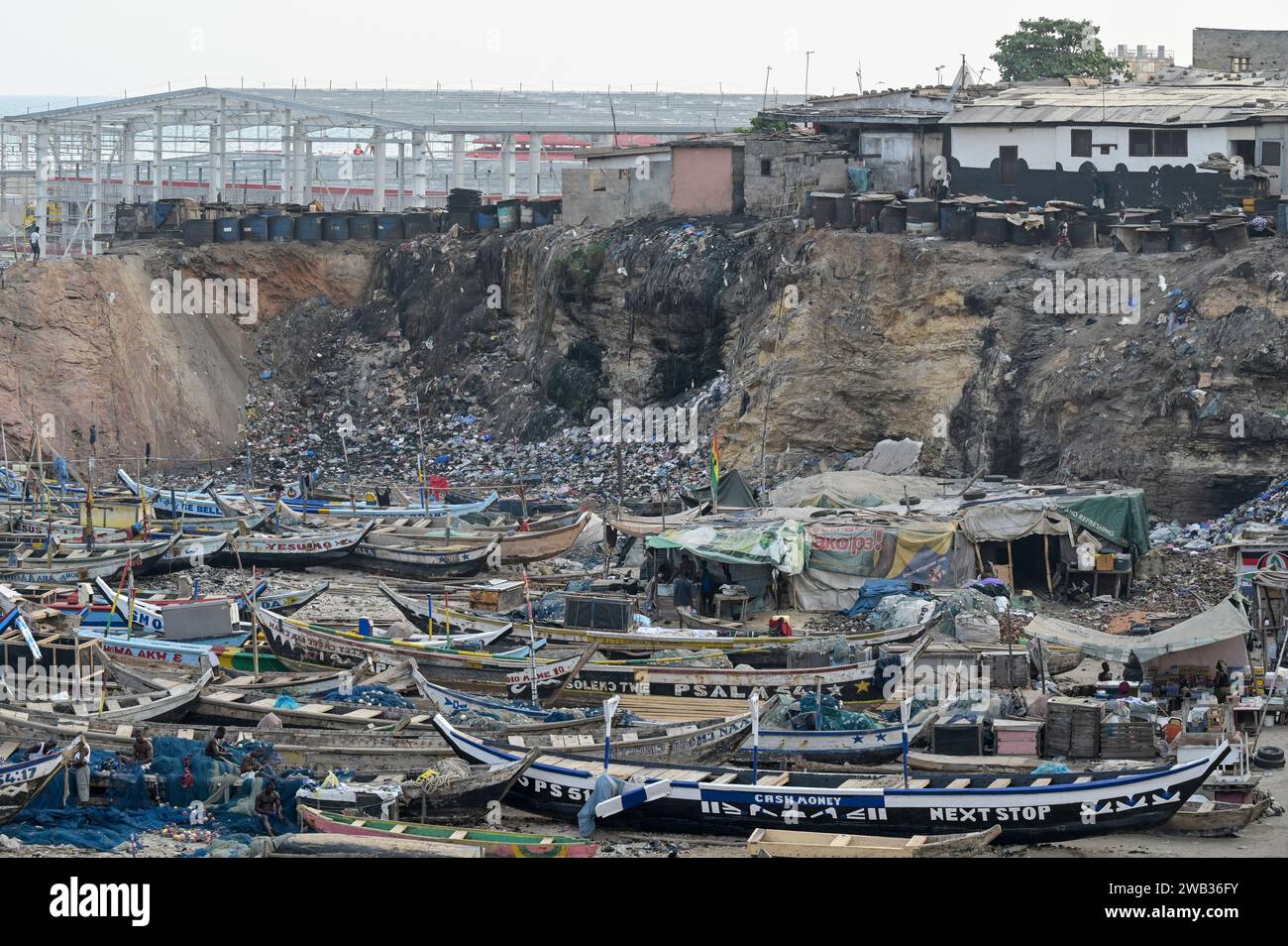 GHANA, Accra, Jamestown, old fishing port and behind construction site of new fishing harbour by chinese company CRCC China Railway Construction Corporation Limited and China Aid  / GHANA, Accra, alter Fischereihafen und hinten Bau eines neuen Fischerei Hafen mit Piers, Fischverarbeitungs- und Kühlhallen durch chinesische Baufirma CRCC und China Aid in Jamestown Stock Photo