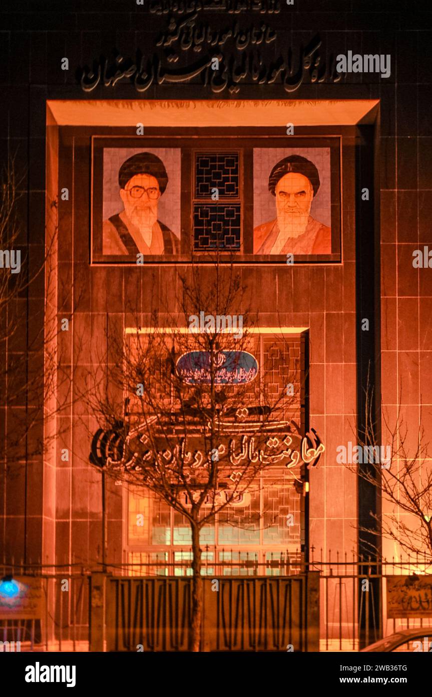 Murals of Imam Khomeini and Ali Khamenei on the facade of a building at night in Isfahan, Iran Stock Photo