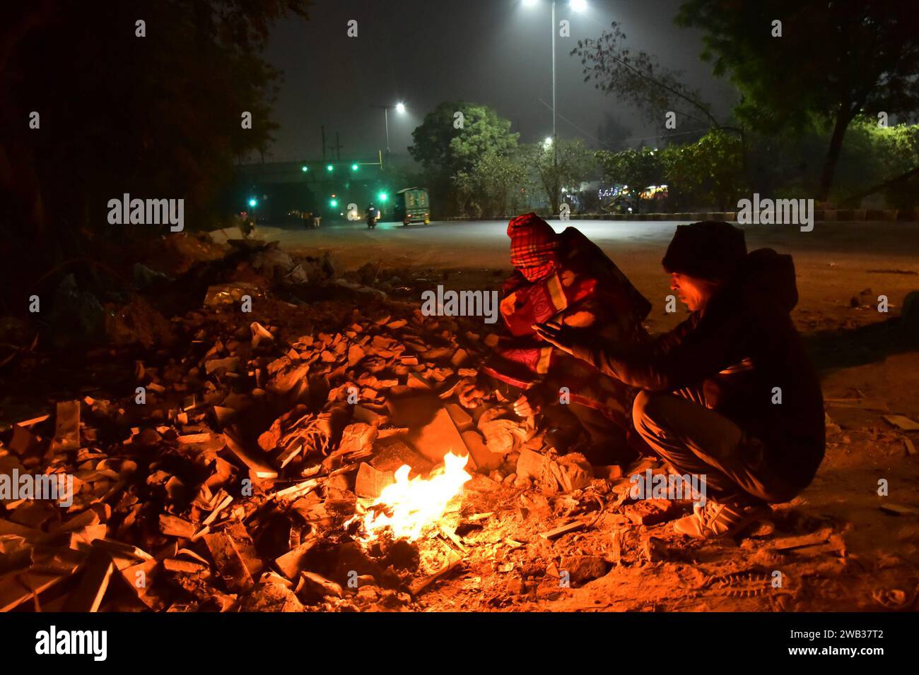 New Delhi, India. 06th Jan, 2024. NEW DELHI, INDIA - JANUARY 6: People sitting around bonfire on a cold morning at Khanpur Bus Depot area on January 6, 2024 in New Delhi, India. Foggy morning challenges Delhi-NCR with intensifying cold wave, mercury dips further across North India. (Photo by Sakib Ali/Hindustan Times/Sipa USA ) Credit: Sipa USA/Alamy Live News Stock Photo