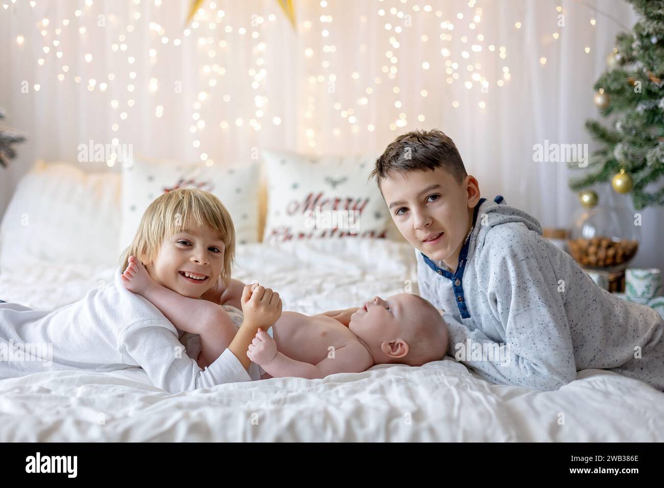 Happy family, newborn baby and older brothers, mom at home on Christmas Stock Photo