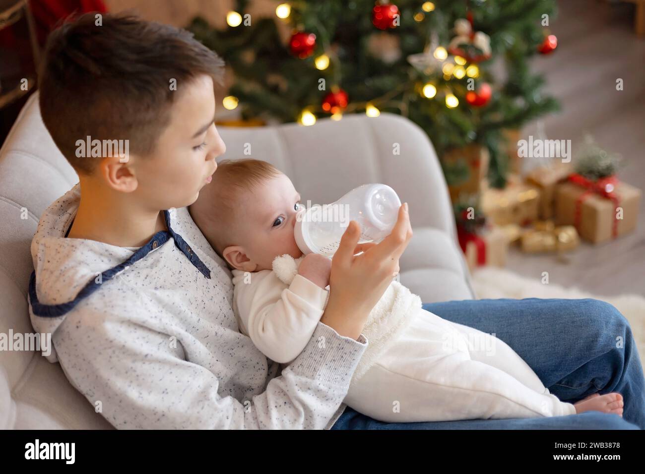 Happy family, newborn baby and older brothers, mom at home on Christmas Stock Photo