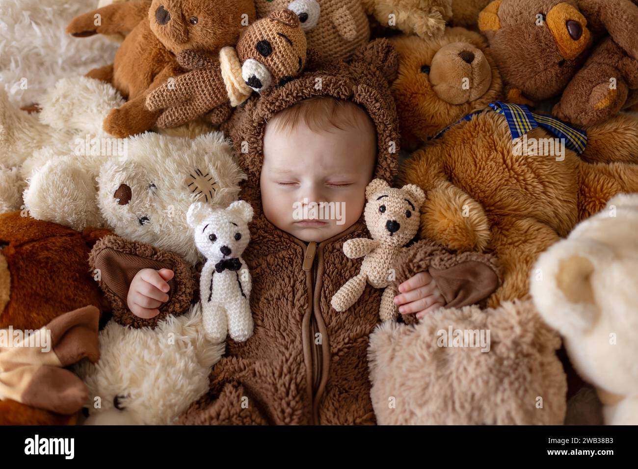 Sweet new boy child,  baby boy in bear overall, sleeping in bed with teddy bears Stock Photo