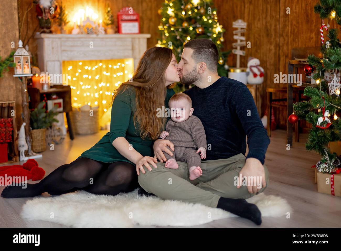 Cute newborn child, baby boy, with mom and dad on Christmas at home, enjoying first christmas holiday Stock Photo