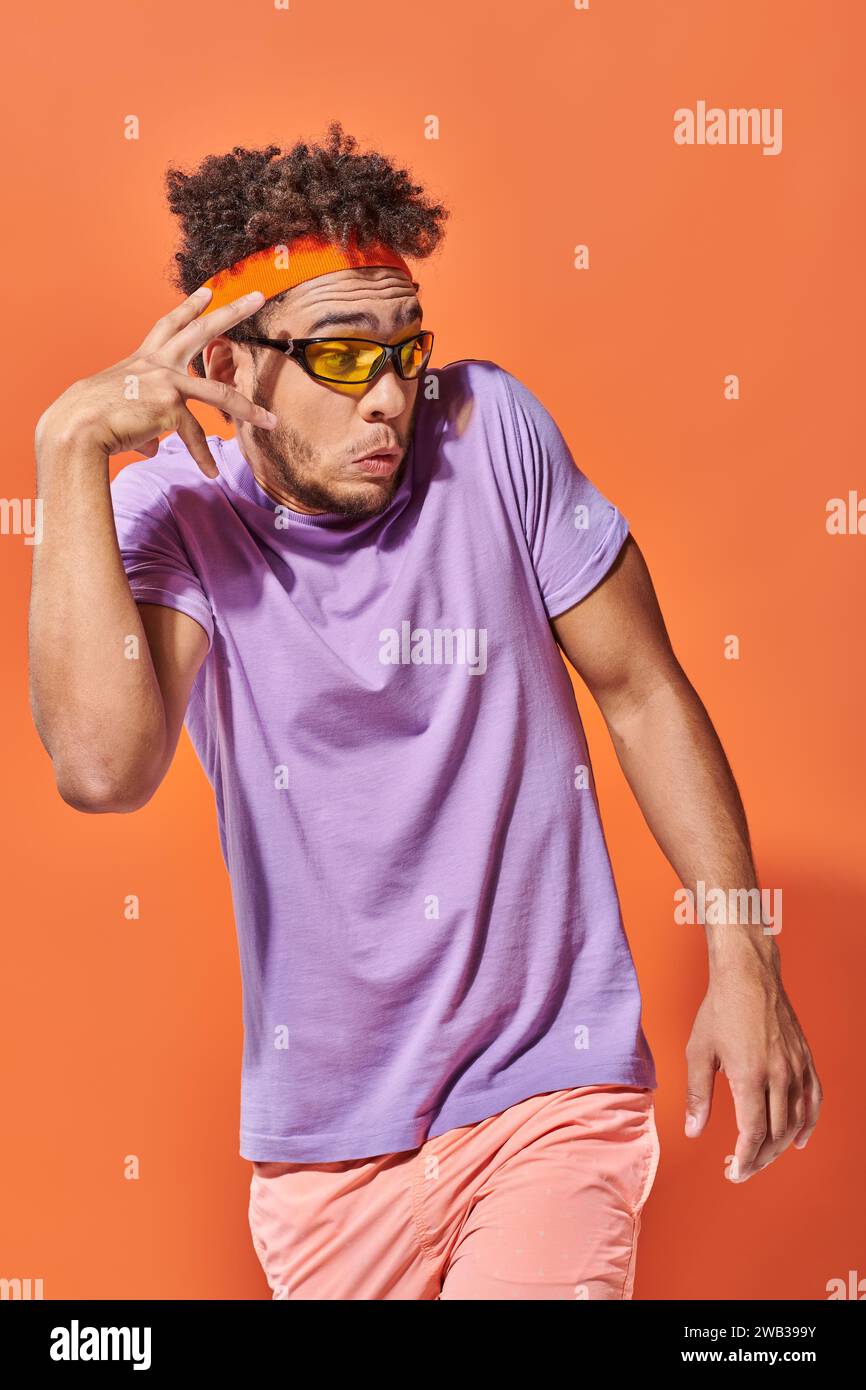 surprised african american man in eyeglasses and headband looking away
