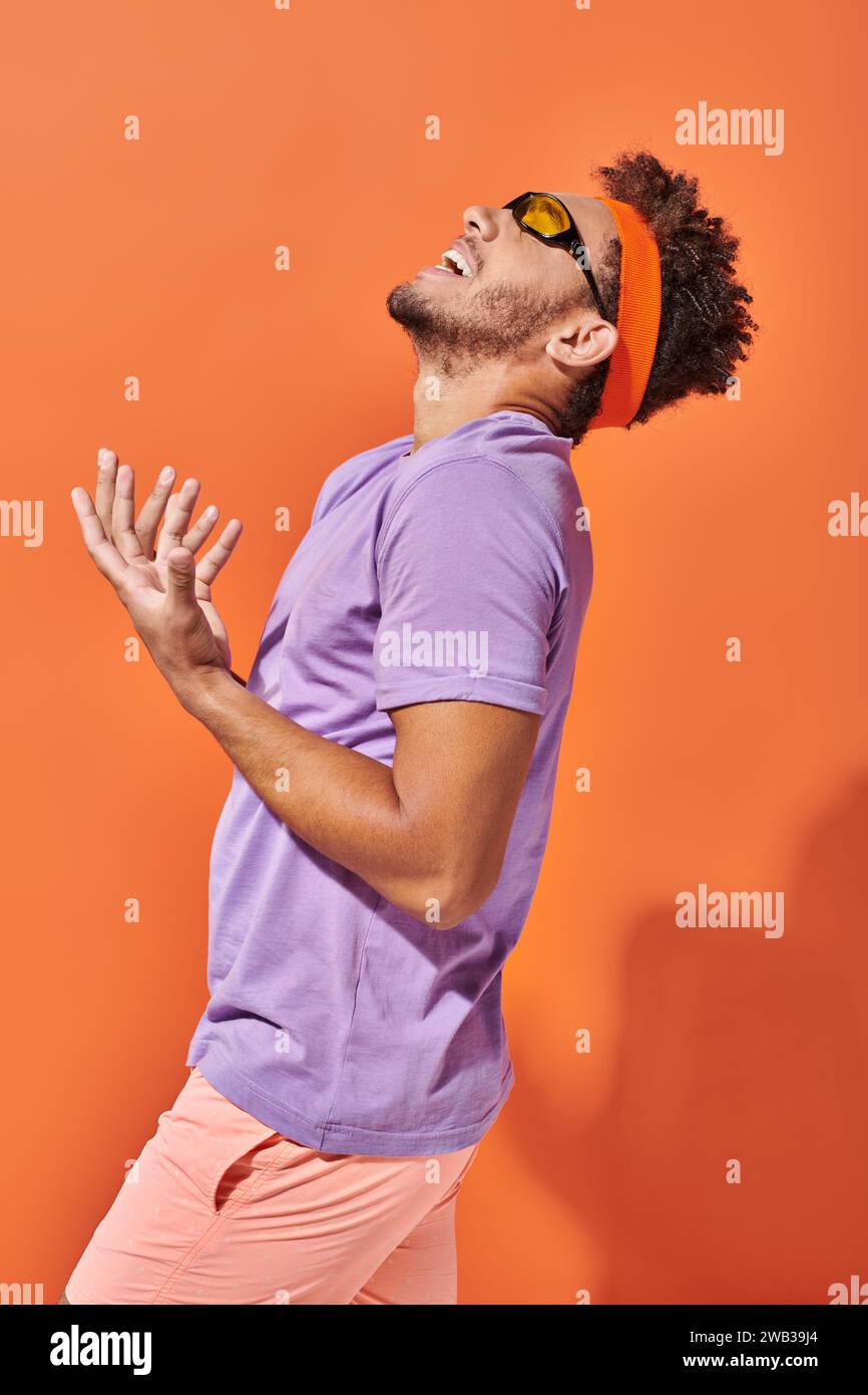 expressive african american man in eyeglasses and headband screaming on