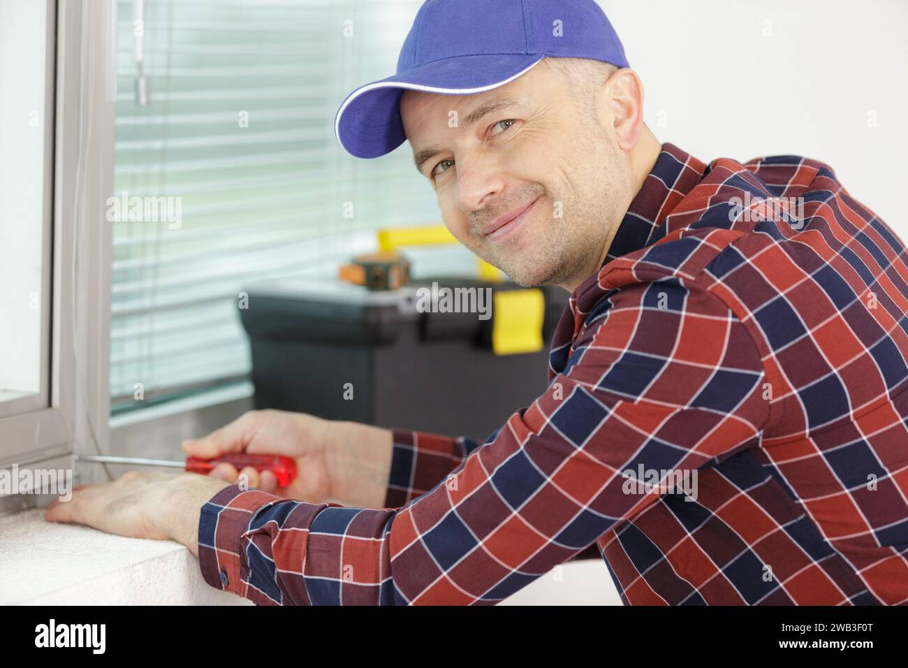 worker fasten the handle to a plastic window Stock Photo
