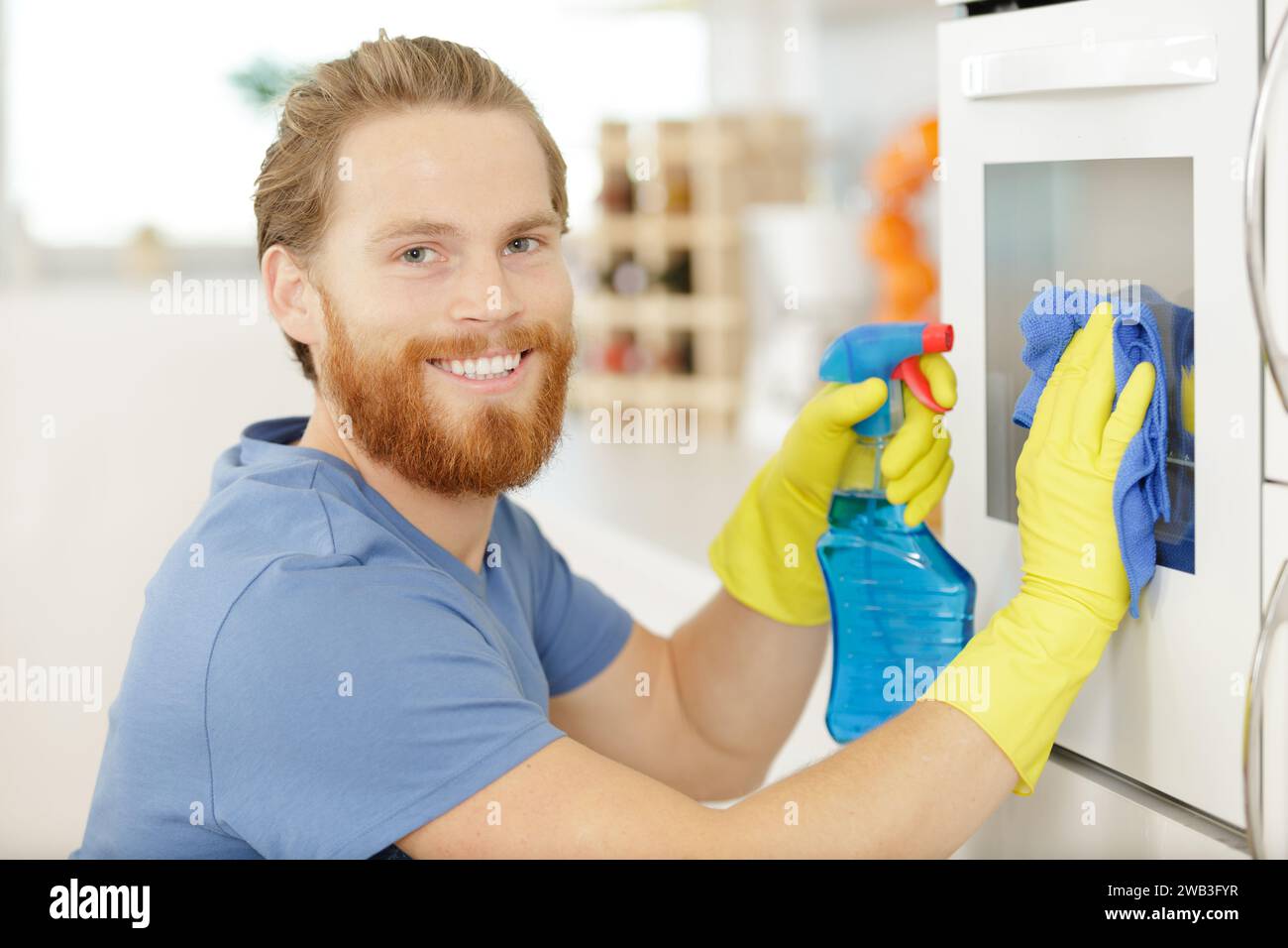 man wiping an oven with table cloth Stock Photo Alamy