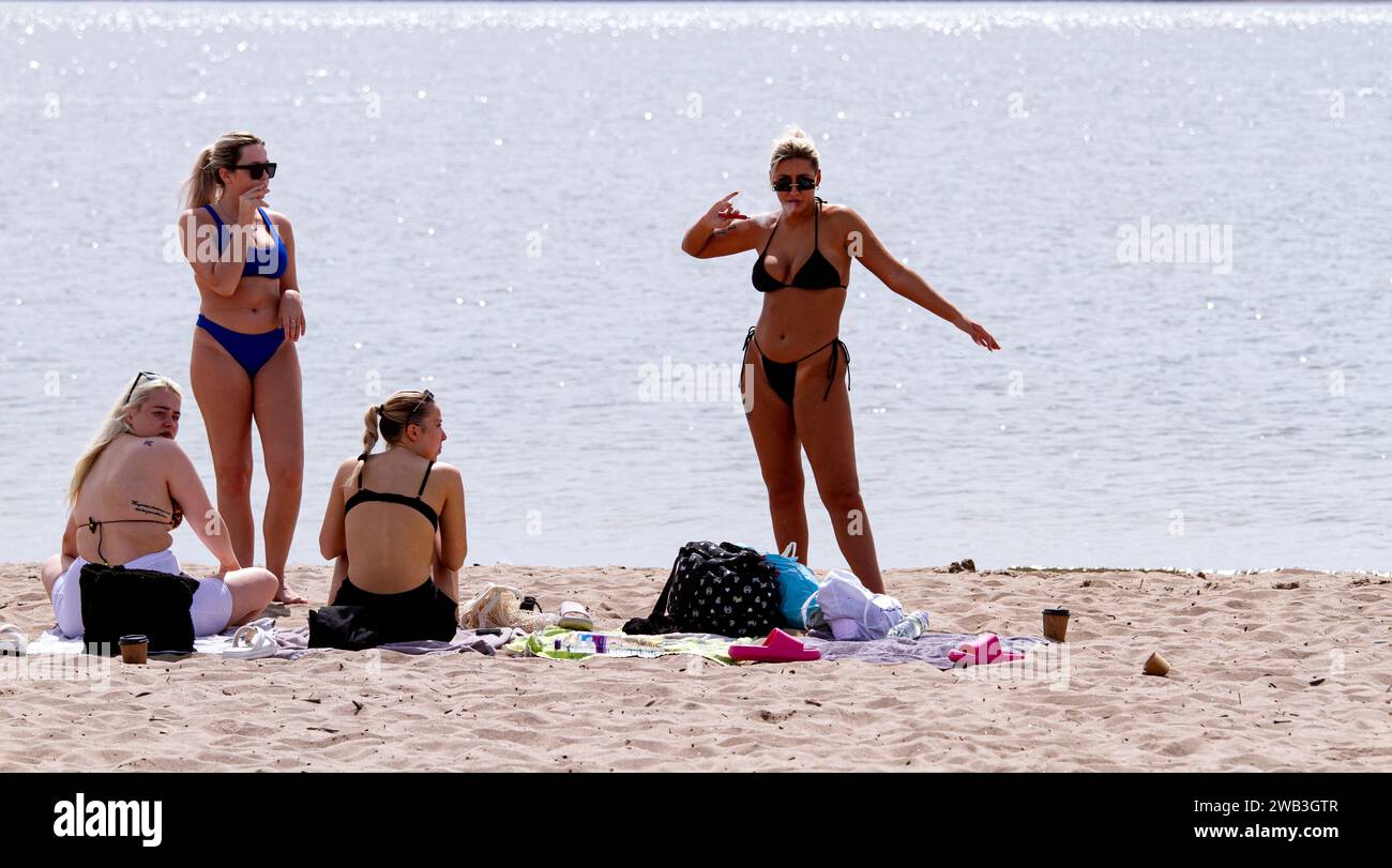 On a glorious hot day in Dundee, local women sunbathe along Broughty Ferry beach during the summer heatwave in Scotland, UK Stock Photo