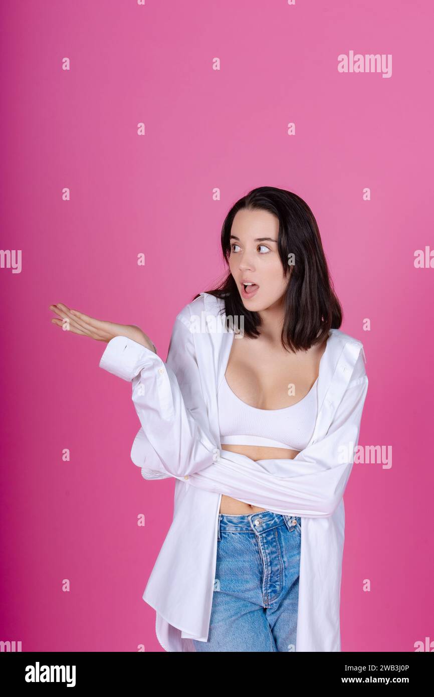 Shocked young lady in white shirt and bralette with a dismissive hand