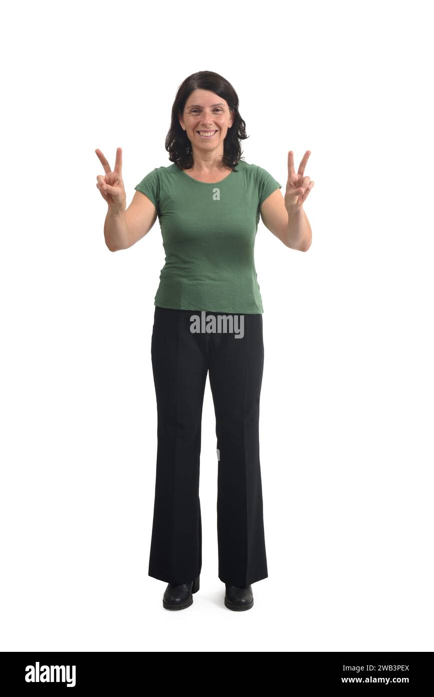 front view of a woman raising two arms showing the victory sign with her fingers on white background. Stock Photo
