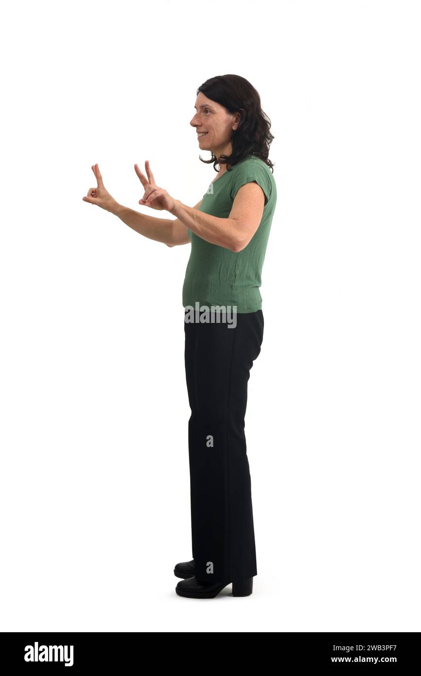 Side view of a woman raising two arms showing the victory sign with her fingers on white background. Stock Photo