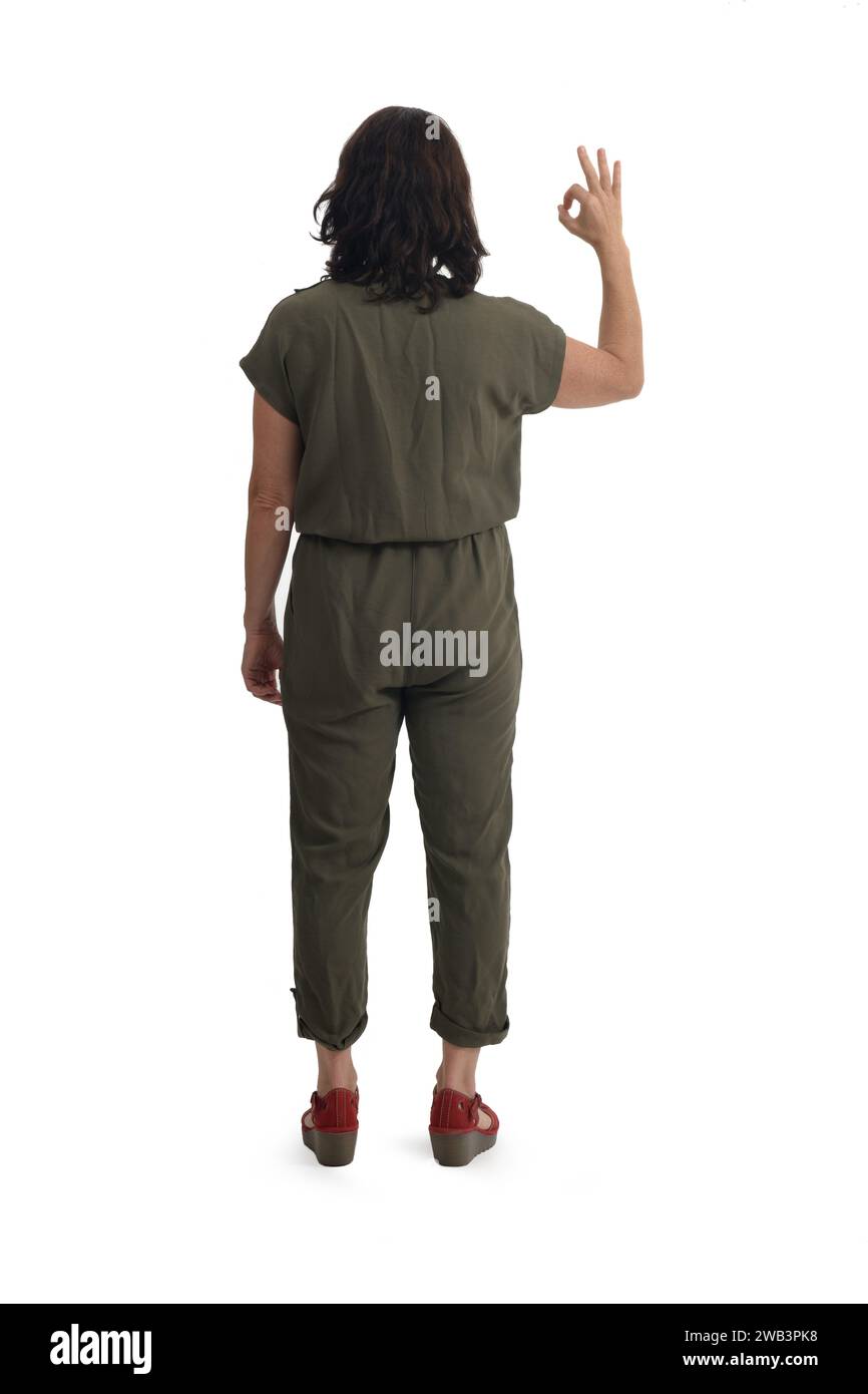 back view of standing woman showing ok sign on white background Stock Photo