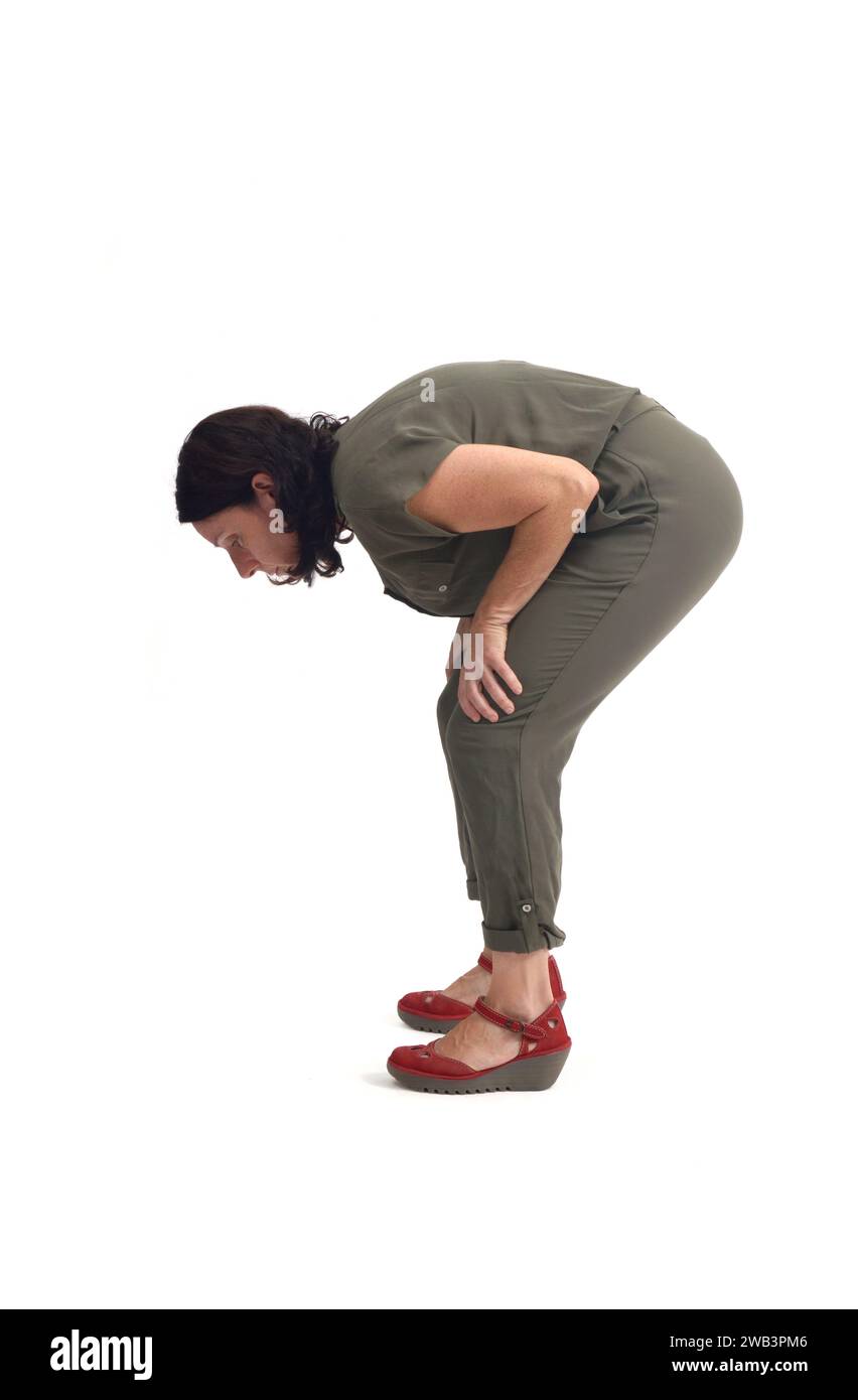 side view of a woman searching for something on the floor on white background Stock Photo