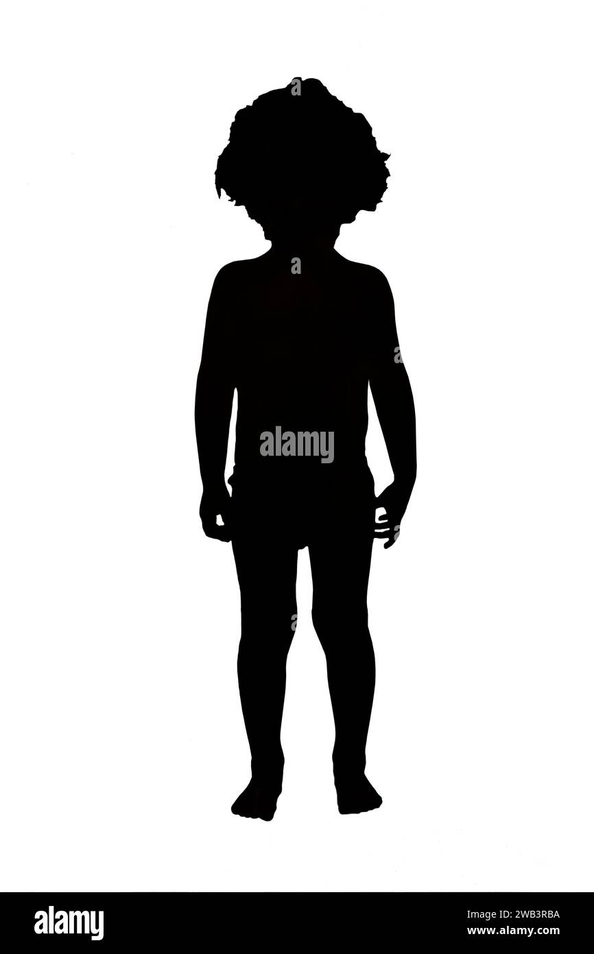 Front view silhouette of a boy in shorts with curly hair standing on white background. Stock Photo