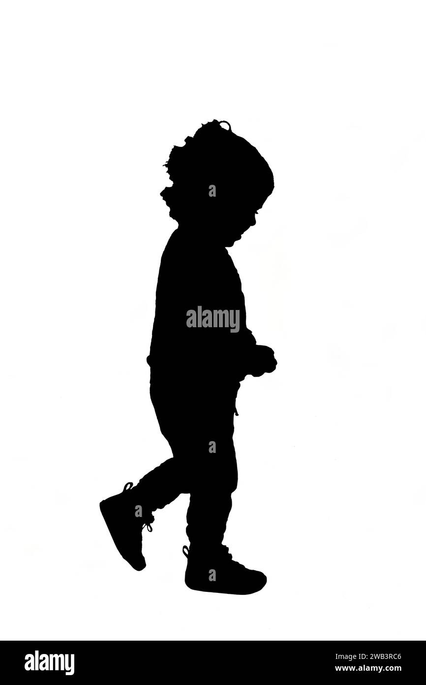 side view of a silhouette baby boy walking on white background Stock Photo