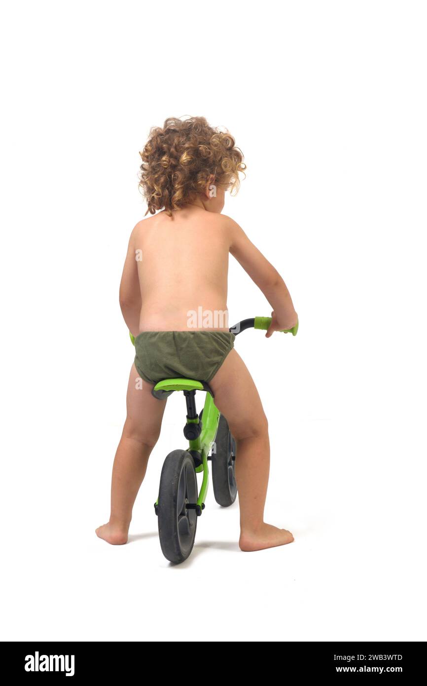 back view of a full length portrait of a boy in underpants on bicycle on a white background Stock Photo