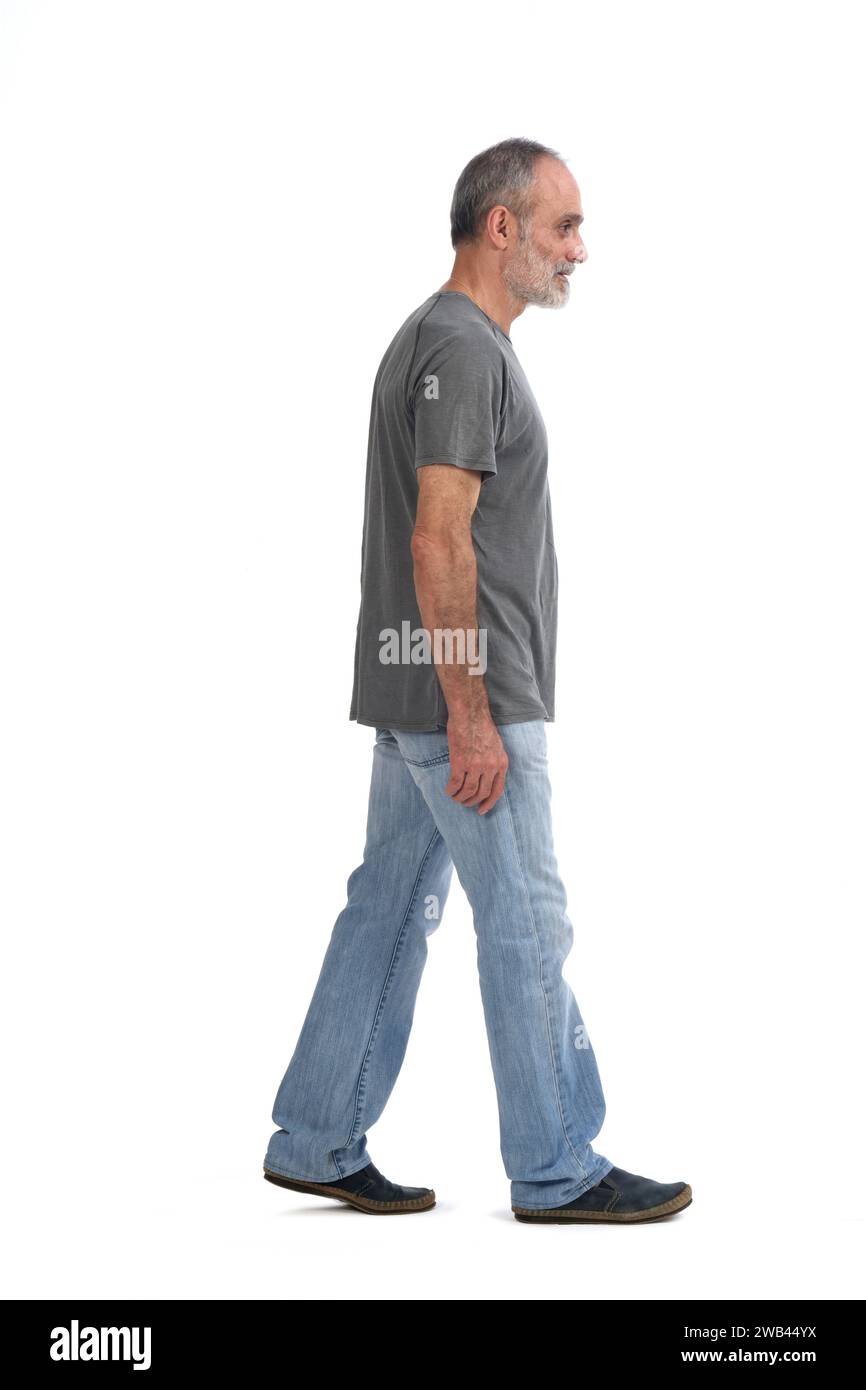 side view of middle aged man walking on white background Stock Photo