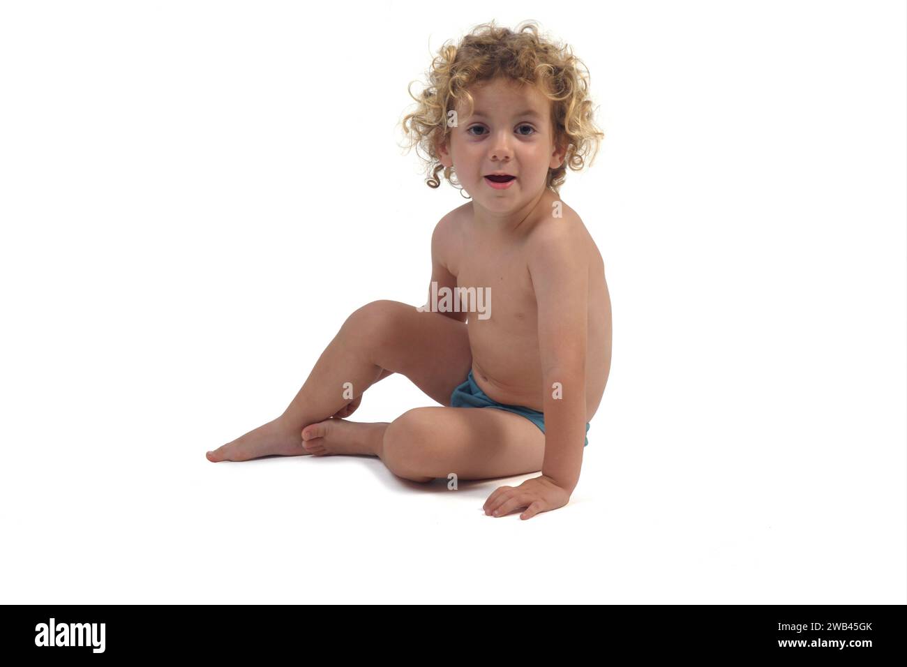 baby boy sitting on the floor looking at camera on white background Stock Photo