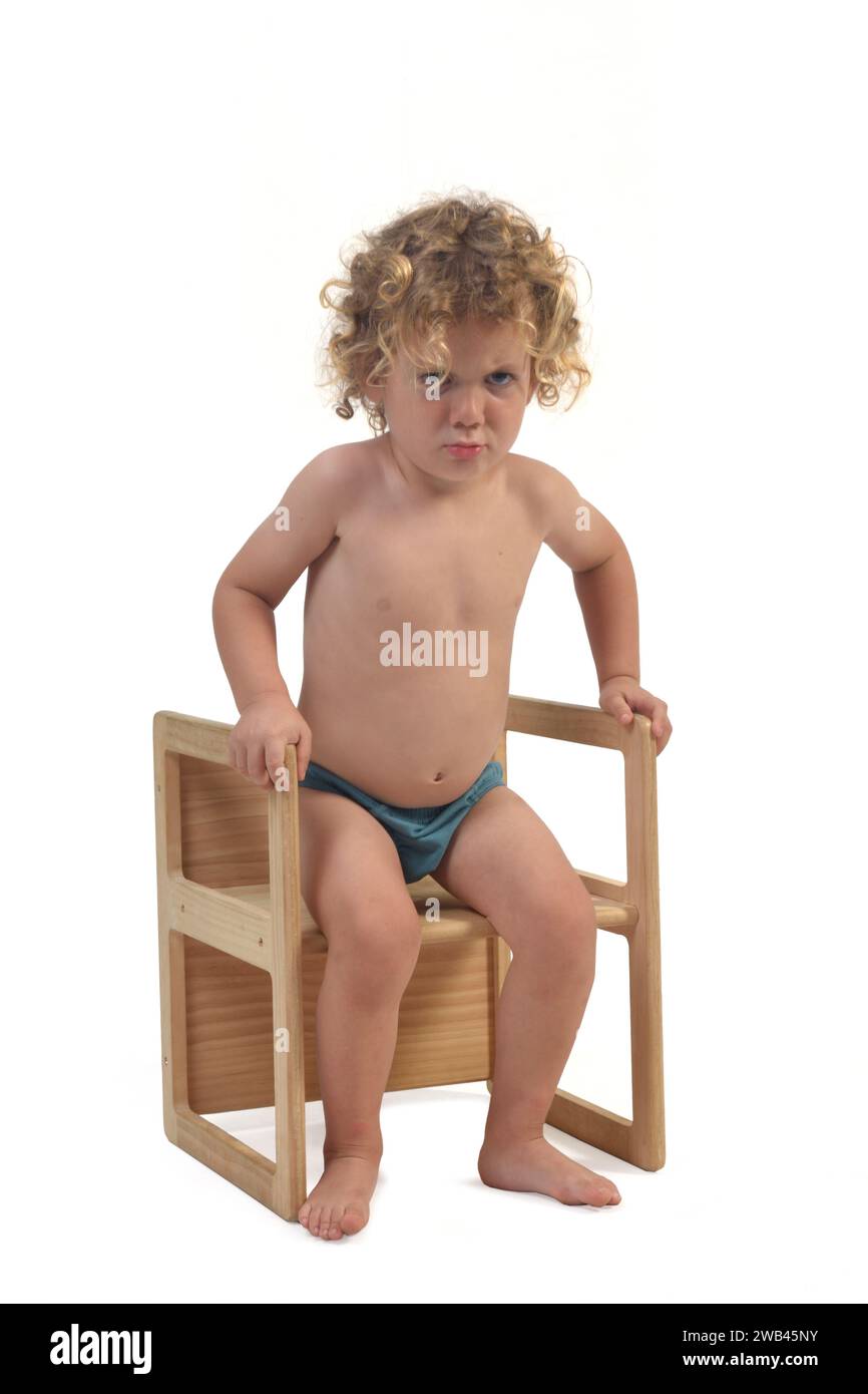 view of a boy in underpants sitting on chair who is angry on white background (3 year old) Stock Photo