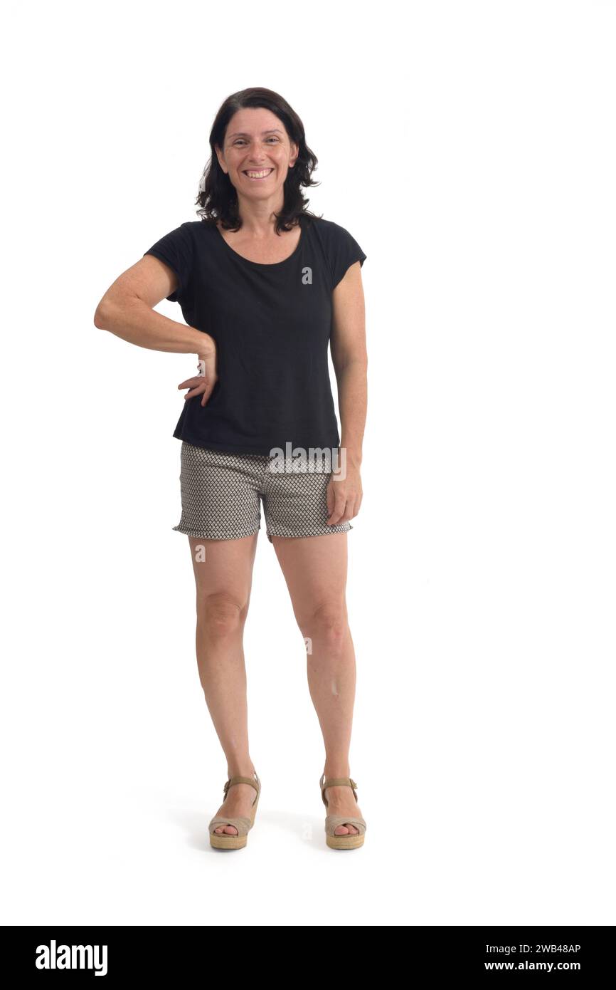 front view of a woman with shorts looking at camera and arm akimbo on white background Stock Photo