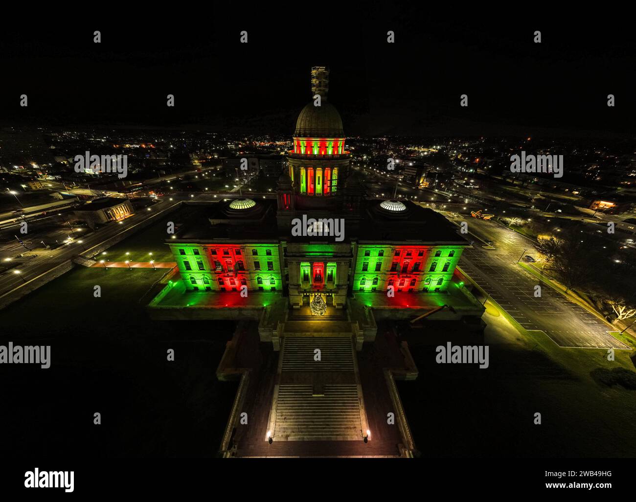 A night shot of a clock tower, illuminated by alternating red and green lights Stock Photo