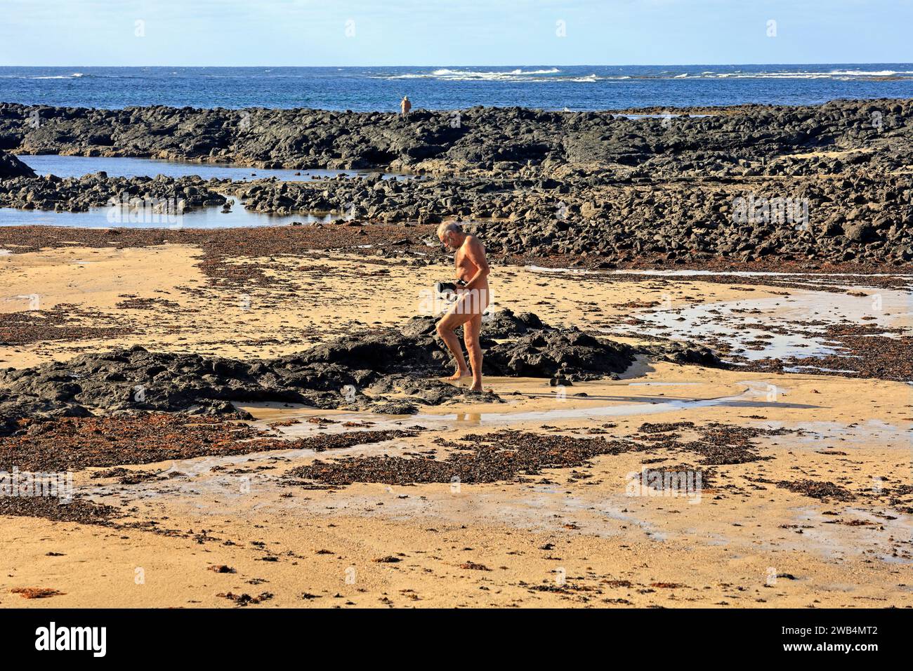 adult-male-nudist-taking-photographs-on-a-beach-el-cotillo