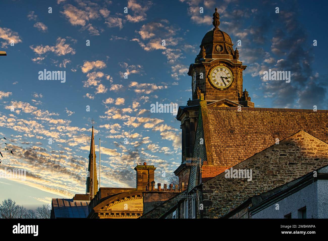 Historic clock tower against a vibrant sunset sky with scattered clouds