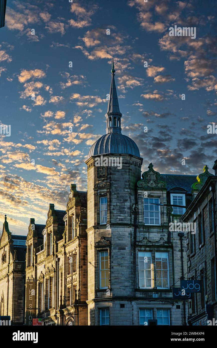 Historic building with a spire against a dramatic sky with golden sunset clouds in Lancaster. Stock Photo