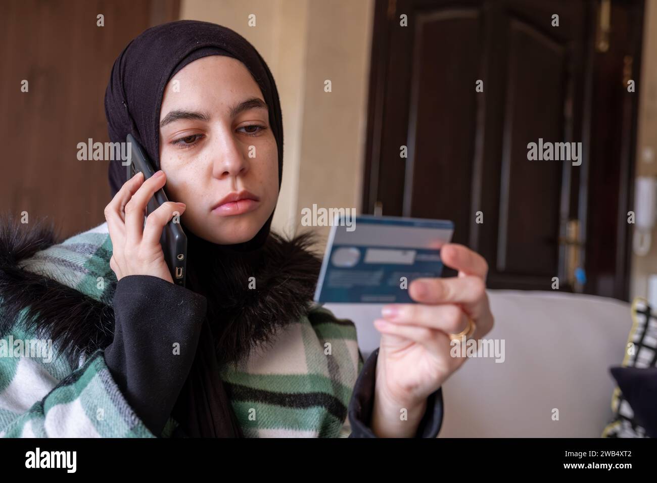 muslim Woman wearing hijab using phone to contact customer care about