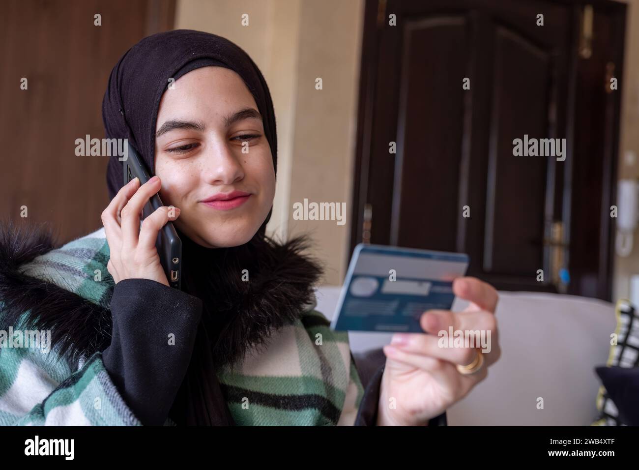 muslim Woman wearing hijab using phone to contact customer care about