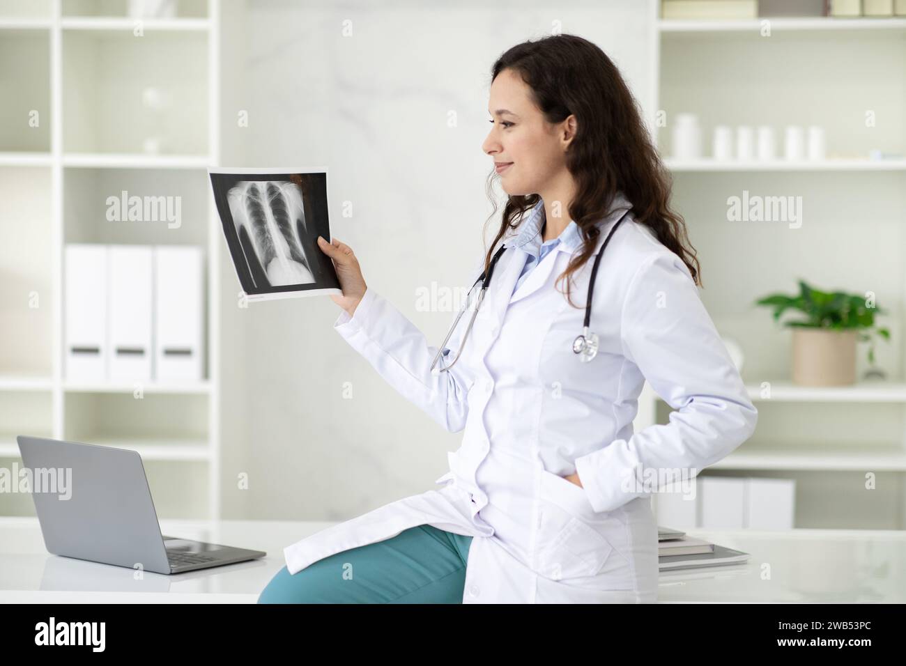 Happy young woman doctor looking at xray radiography image Stock Photo ...