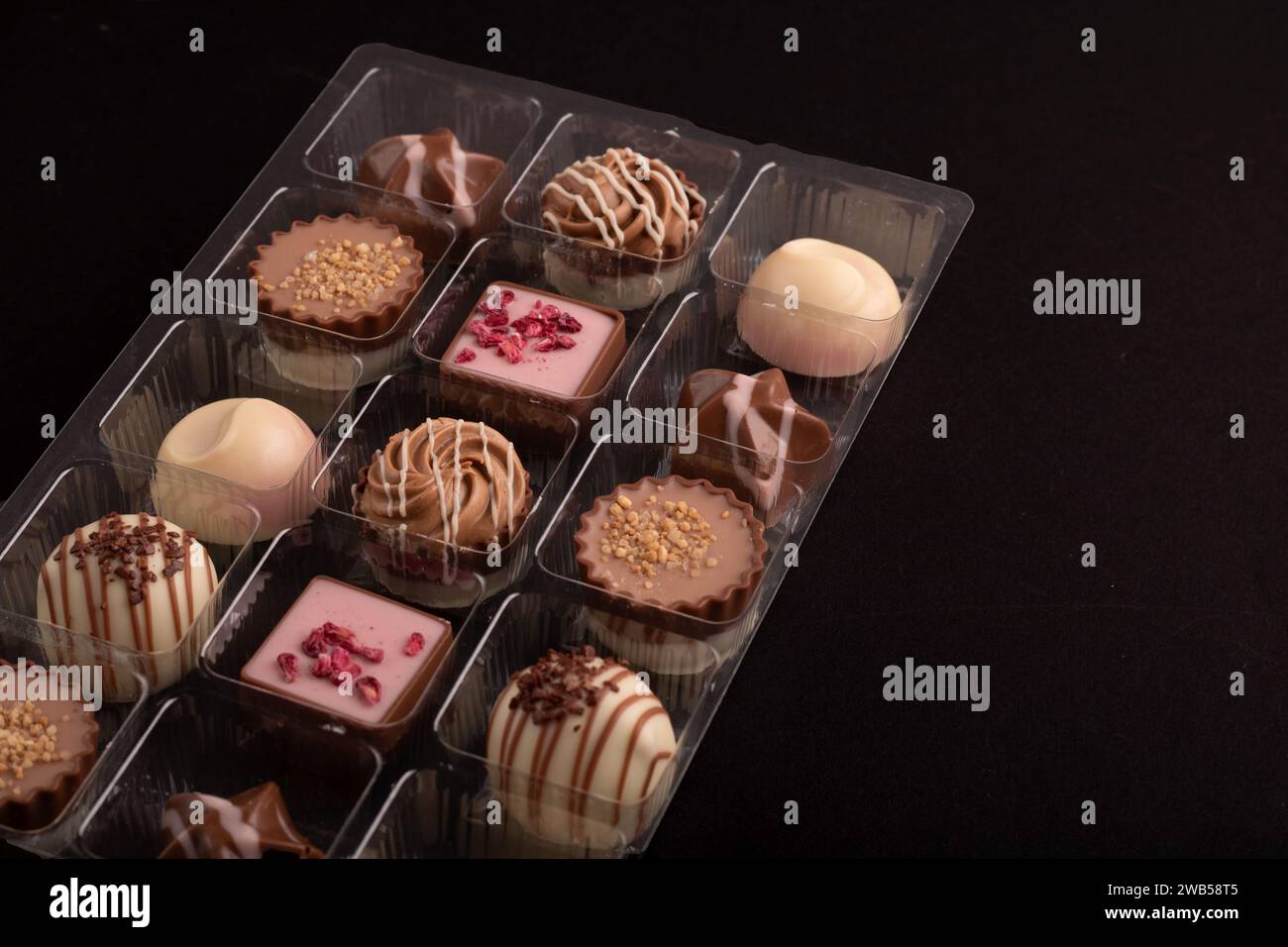assortment of chocolates in a captivating box. Each piece promises a symphony of flavors, from rich cocoa to sugar, creating a tempting treat for the Stock Photo