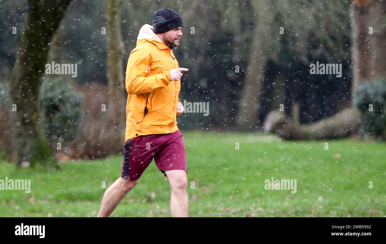 London, UK. 8th Jan, 2024. A man jogs in snow in London, Britain, on