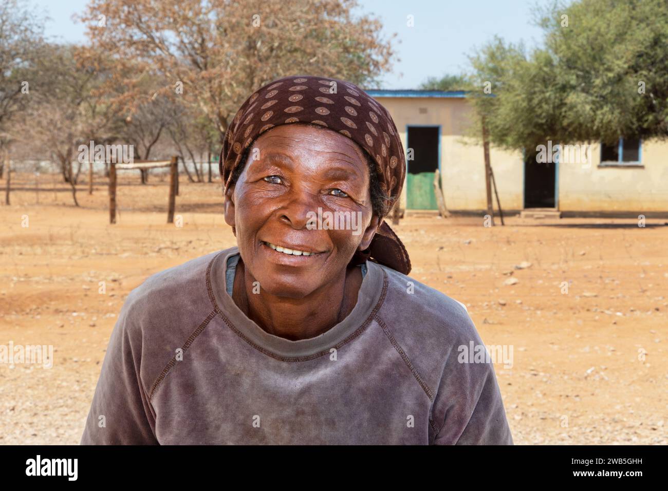 portrait of old african woman in the village, house in the background Stock Photo