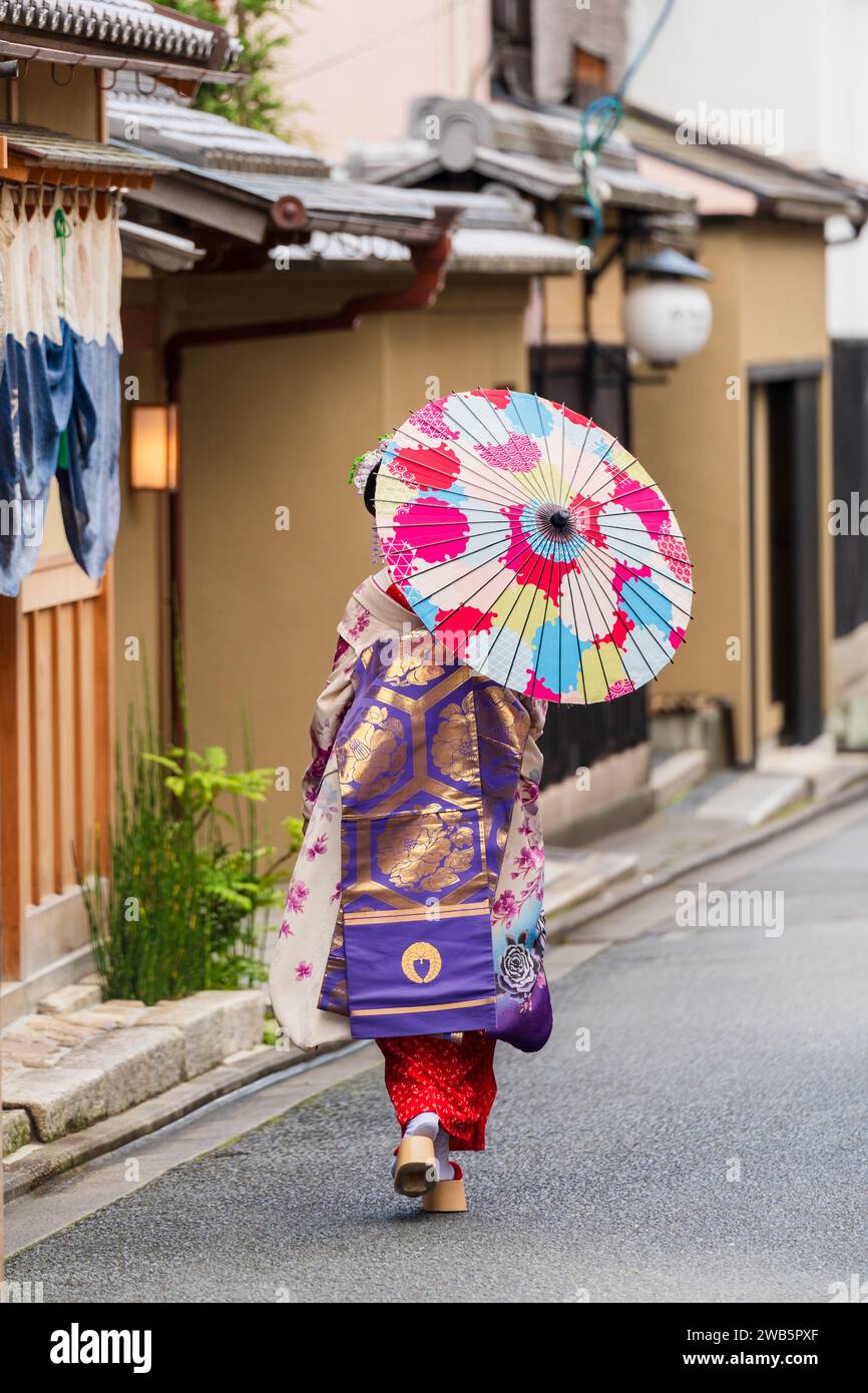 Geisha holding paper umbrella walking on the street in Gion Kyoto, Japan. Stock Photo