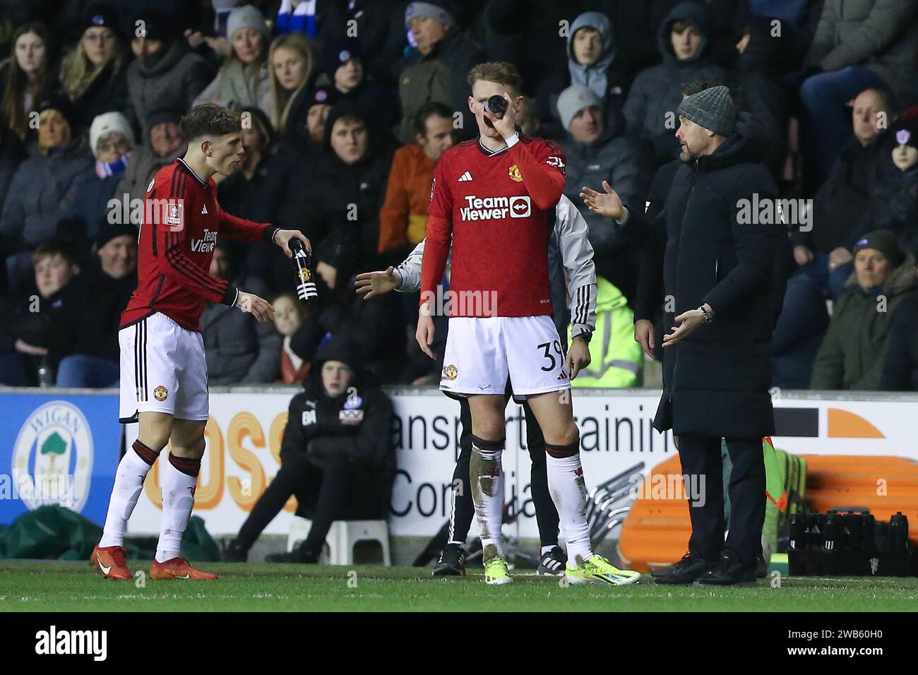 Wigan, UK. 08th Jan, 2024. Erik ten Hag, the Manchester United Manager (r) gives instructions to his players Scott McTominay of Man Utd (39) & Alejandro Garnacho of Man Utd (l) as they take a drink. Emirates FA Cup, 3rd round match, Wigan Athletic v Manchester Utd at the DW Stadium in Wigan, Lancs on Monday 8th January 2024. this image may only be used for Editorial purposes. Editorial use only, pic by Chris Stading/Andrew Orchard sports photography/Alamy Live news Credit: Andrew Orchard sports photography/Alamy Live News Stock Photo