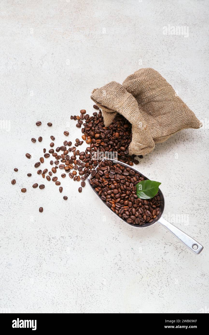 Sack bag and scoop with coffee beans on light background Stock Photo