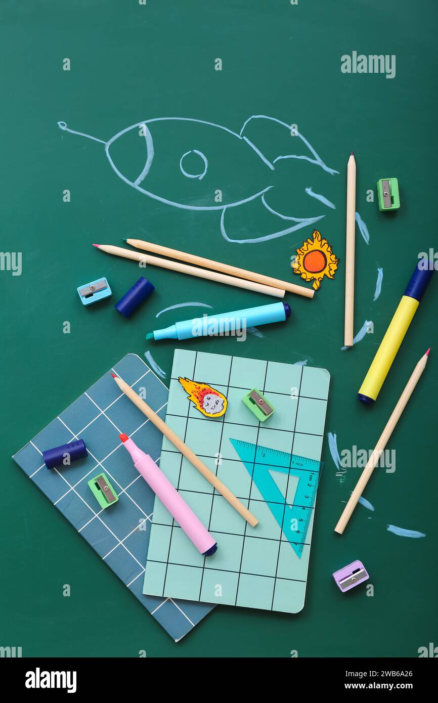 Creative composition with drawn rocket and different stationery on green chalkboard Stock Photo