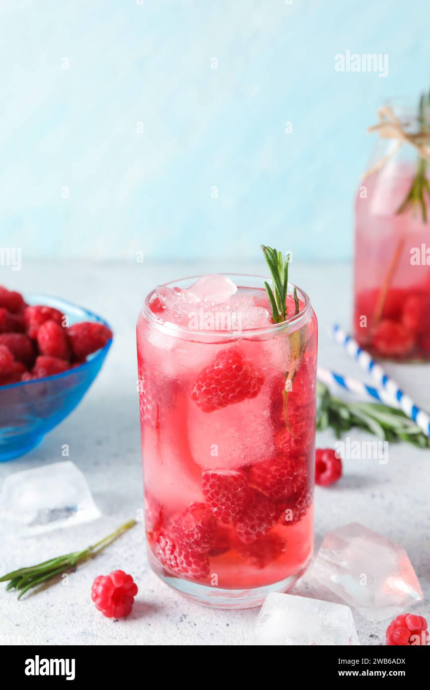 Glass and bottle of fresh raspberry lemonade with rosemary on white ...