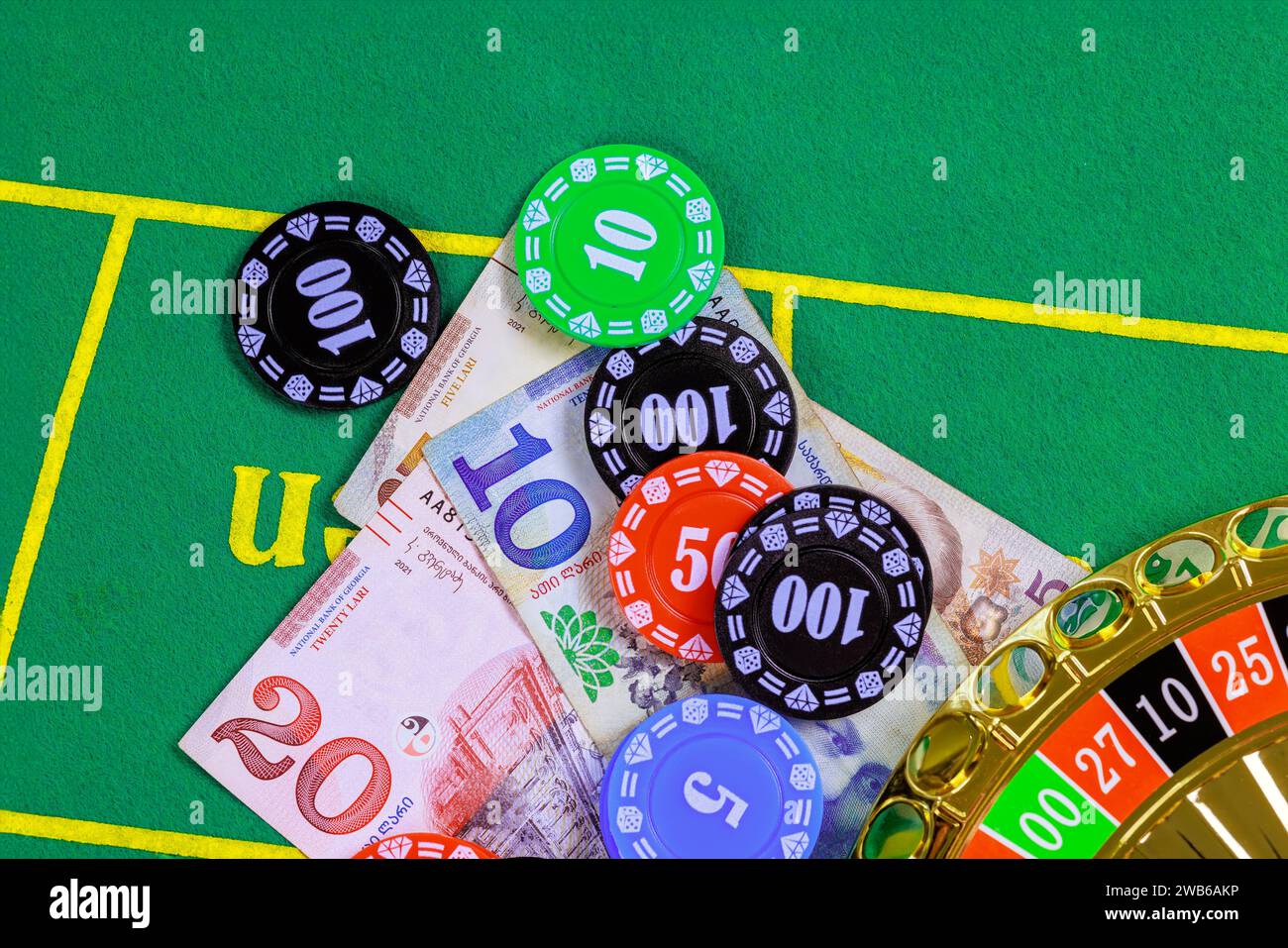 On green gaming table are roulette Georgian banknotes lari poker chips. Stock Photo