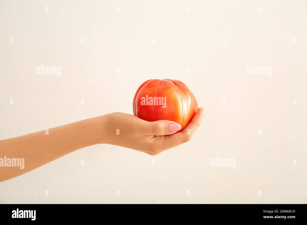 Female hand with fresh ripe tomato on white background Stock Photo - Alamy