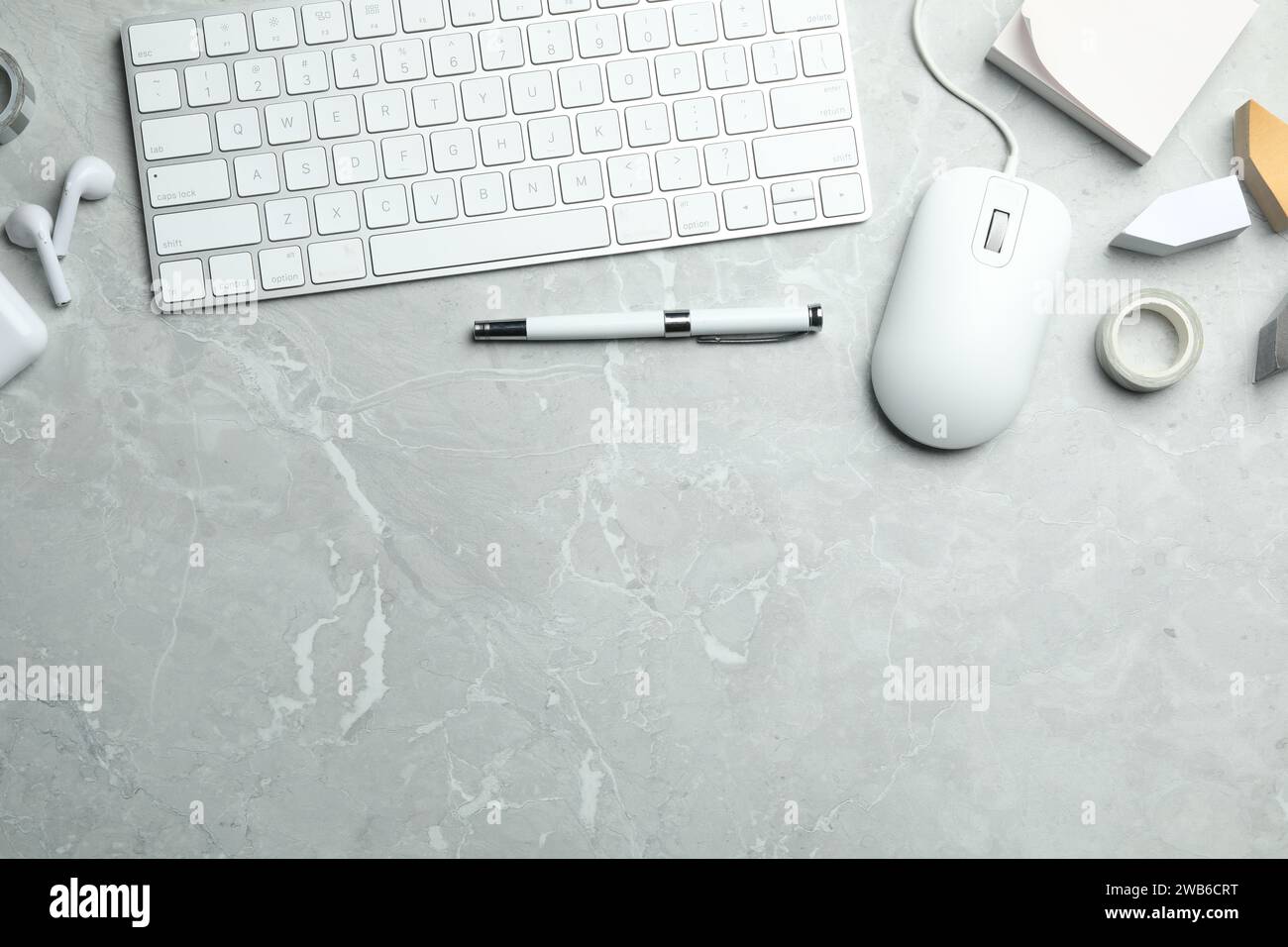 Flat lay composition with wired computer mouse and keyboard on light grey marble table. Space for text Stock Photo