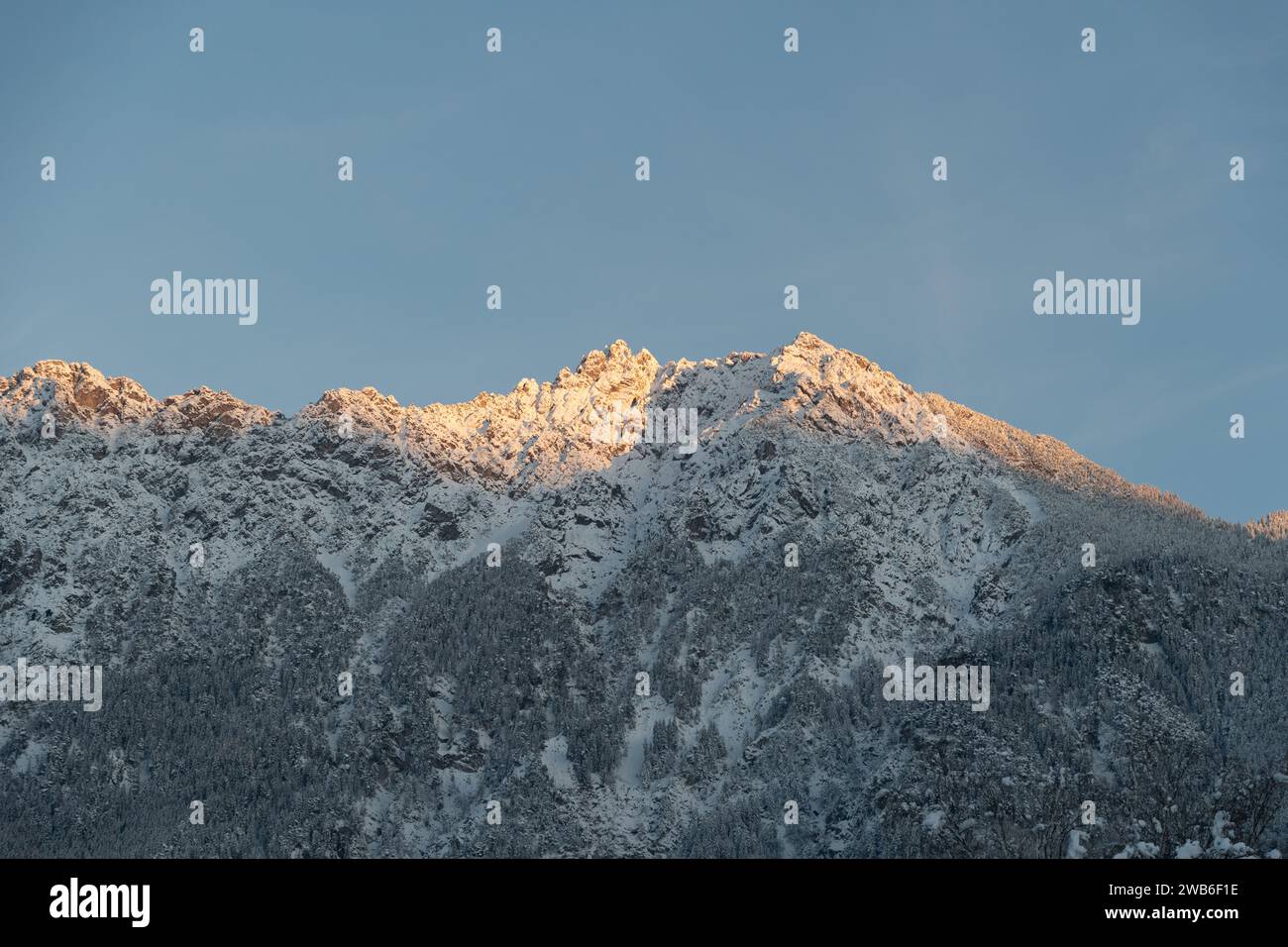 Vaduz, Liechtenstein, December 3, 2023 Last sun rays on the peak of the snow covered mountains Stock Photo