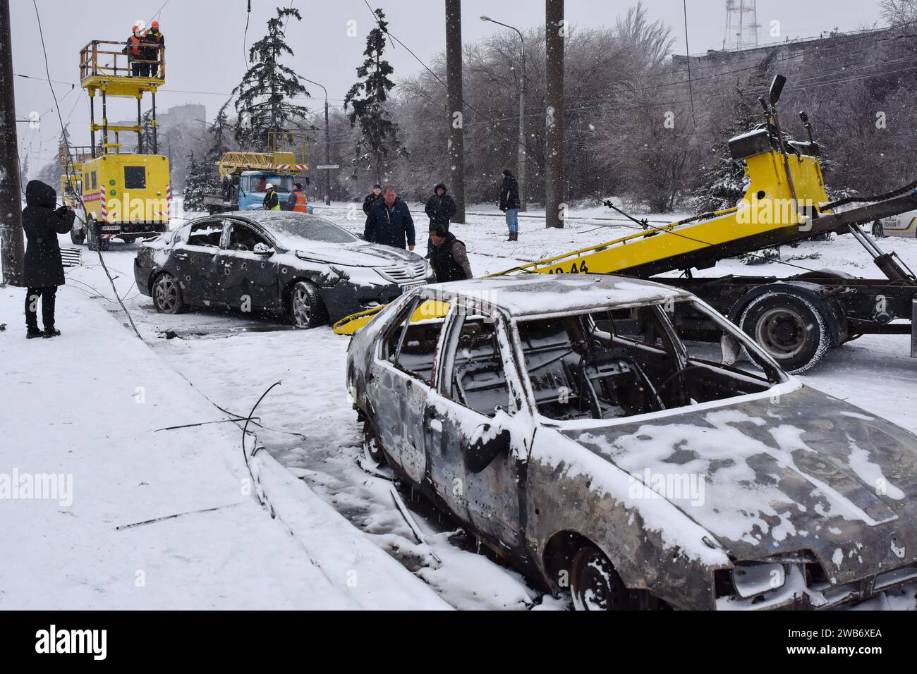 Zaporizhzhia, Ukraine. 08th Jan, 2024. A municipal worker and a car owner load the destroyed car on the tow truck following the Russian shelling in Zaporizhzhia. Russia unleashes a further wave of missile and drone strikes across several regions in Ukraine Monday (January 8) with 45 people injured and 4 people have been reported dead. The situation on the front line remained relatively stable, according to Ukrainian President Volodymyr Zelenskyy. Credit: SOPA Images Limited/Alamy Live News Stock Photo