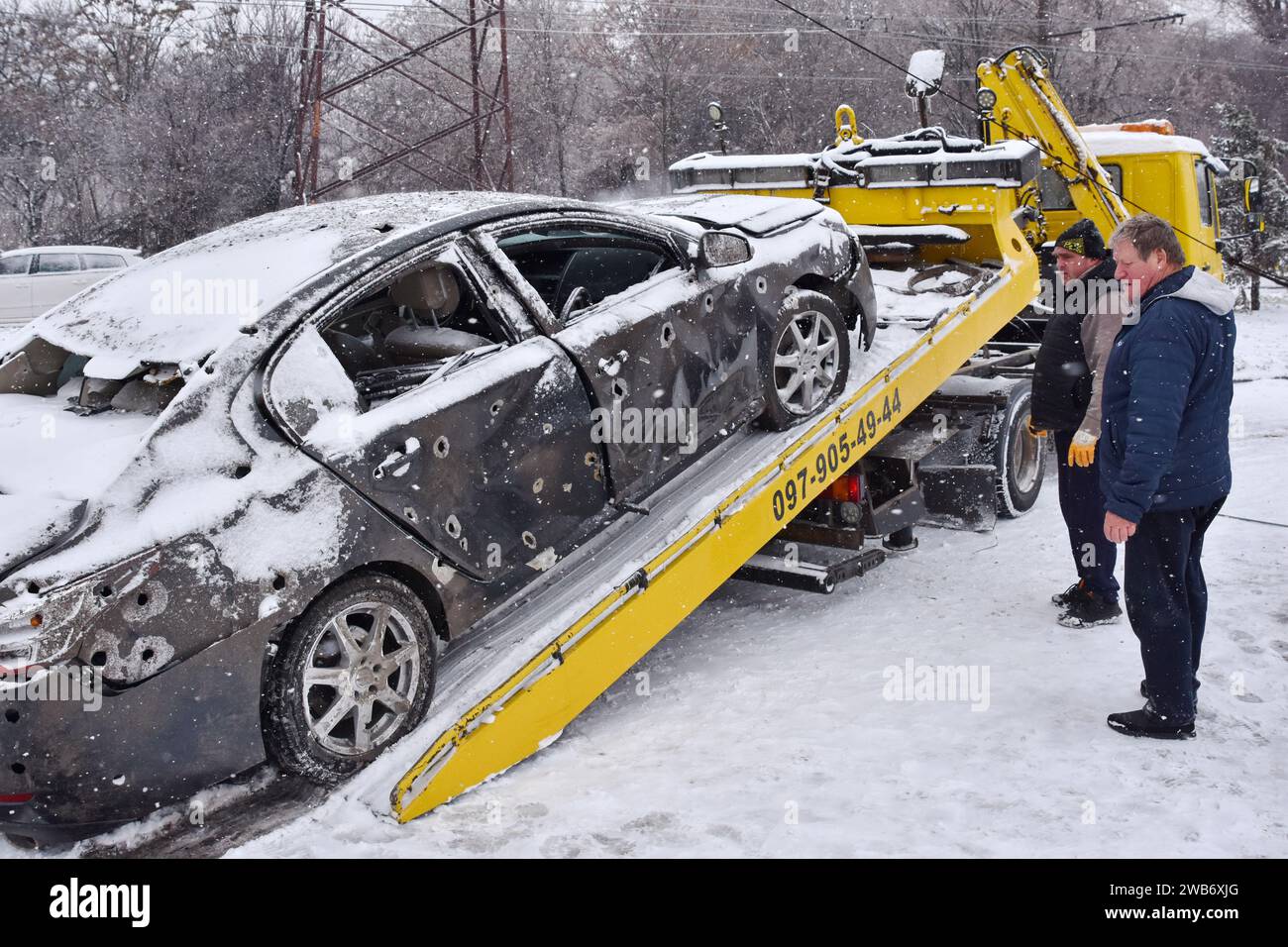 Zaporizhzhia, Ukraine. 08th Jan, 2024. A municipal worker and a car owner load the destroyed car on the tow truck following the Russian shelling in Zaporizhzhia. Russia unleashes a further wave of missile and drone strikes across several regions in Ukraine Monday (January 8) with 45 people injured and 4 people have been reported dead. The situation on the front line remained relatively stable, according to Ukrainian President Volodymyr Zelenskyy. (Photo by Andriy Andriyenko/SOPA Images/Sipa USA) Credit: Sipa USA/Alamy Live News Stock Photo