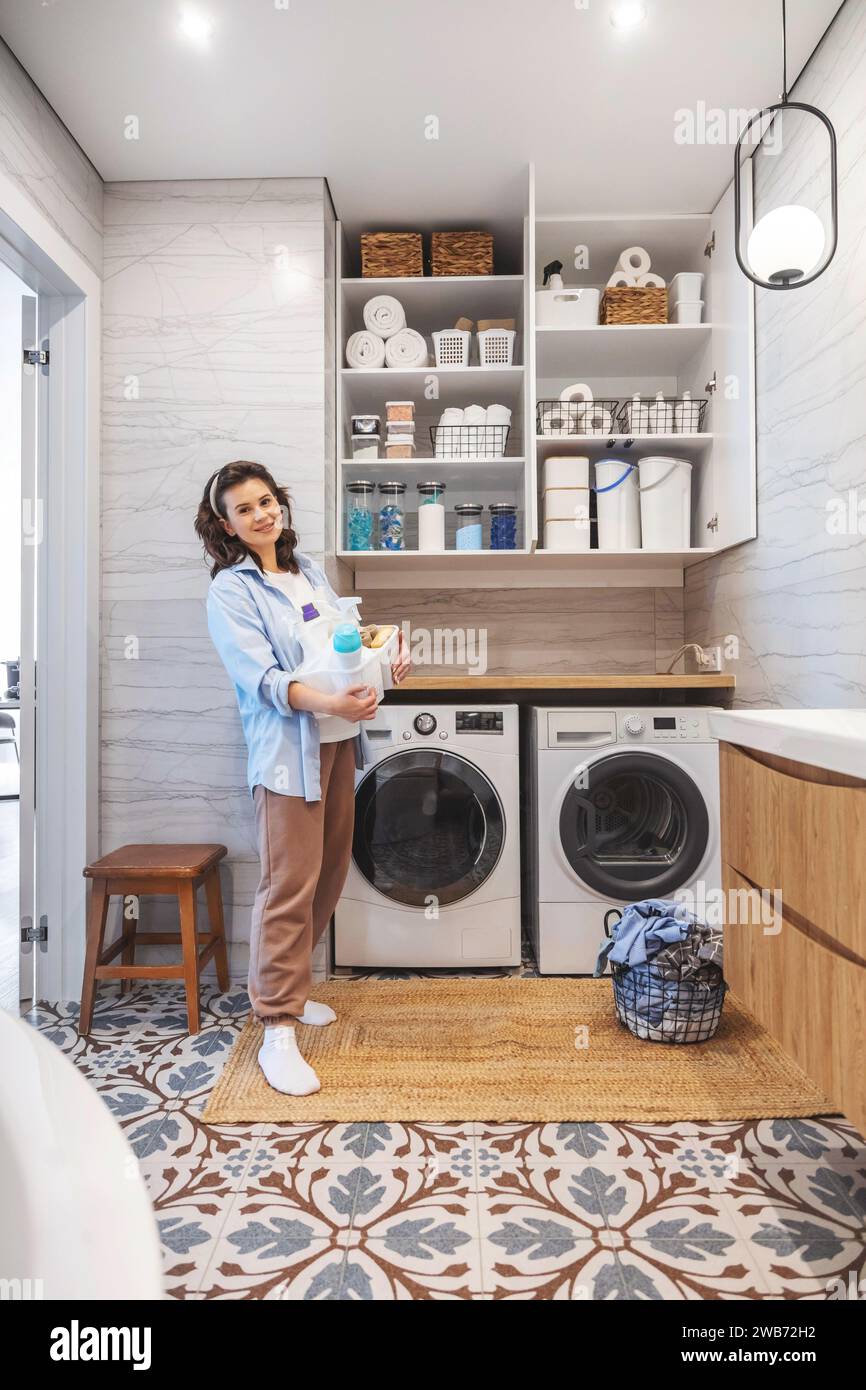 Woman housewife posing at modern white wooden bathroom laundry storage minimalism organizing Stock Photo