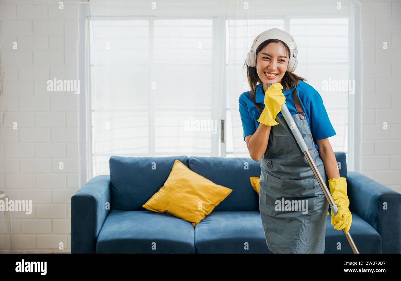 Happy Asian housewife finds joy in cleaning singing her favorite song